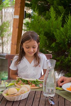 Famiglia felice mangia all'aperto con piatti salutari.
