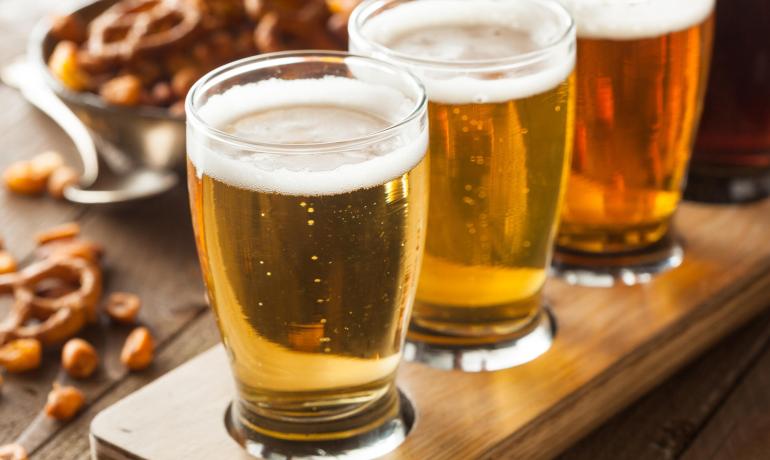 Craft beer tasting with salty snacks on the table.