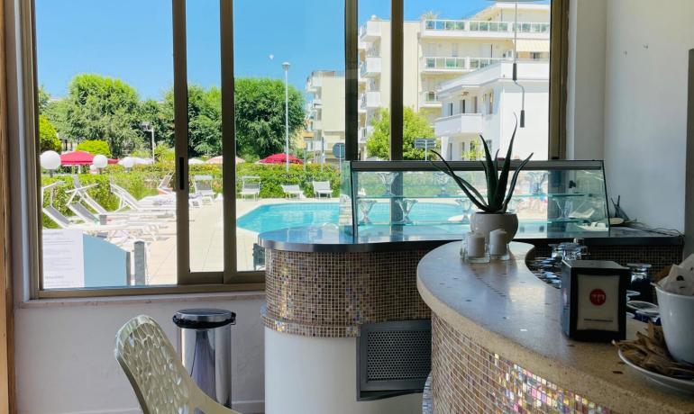 Bar con vista piscina, arredamento moderno e luminoso.