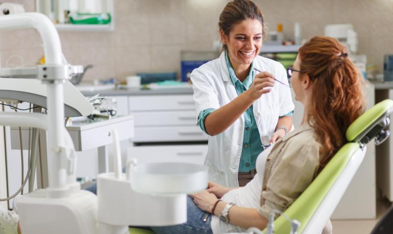 Dentista sorridente cura paziente in studio moderno.