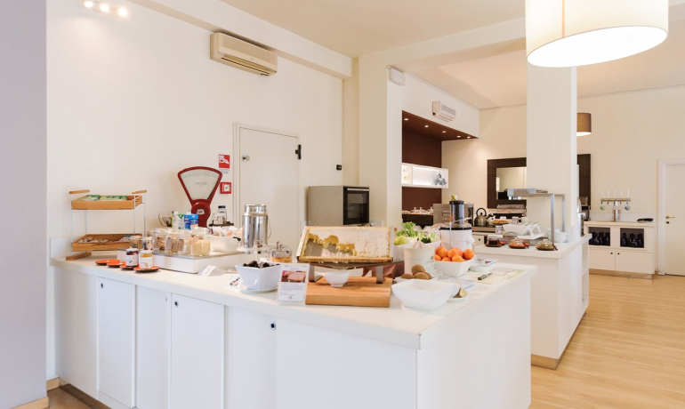 Hotel breakfast buffet with fruits and pastries.